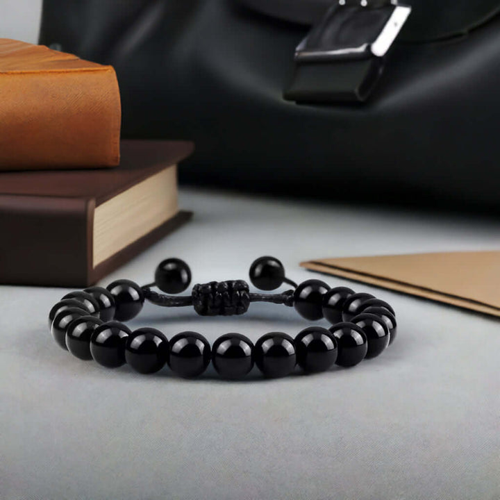Black men's adjustable drawstring bracelet made with natural onyx beads, perfect for layering with jewelry.