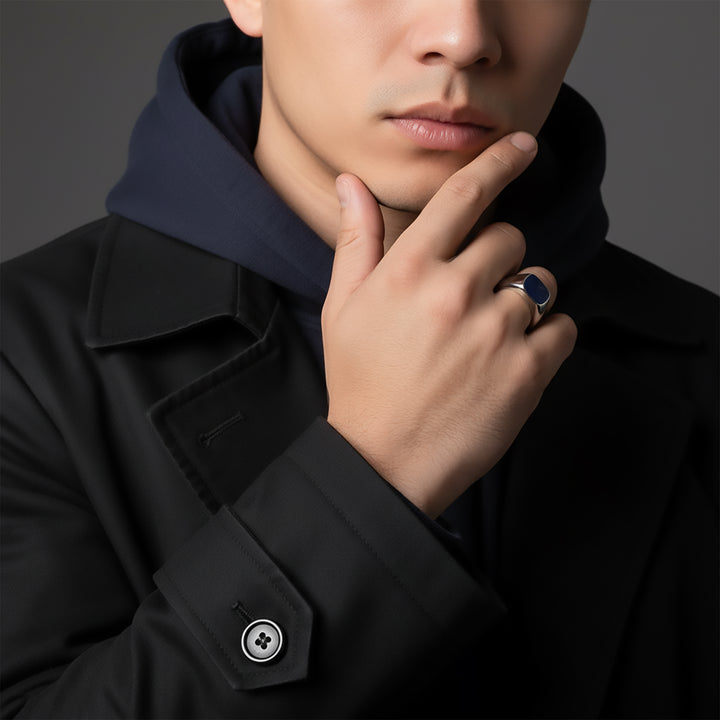 Man wearing a black coat and blue stone signet ring