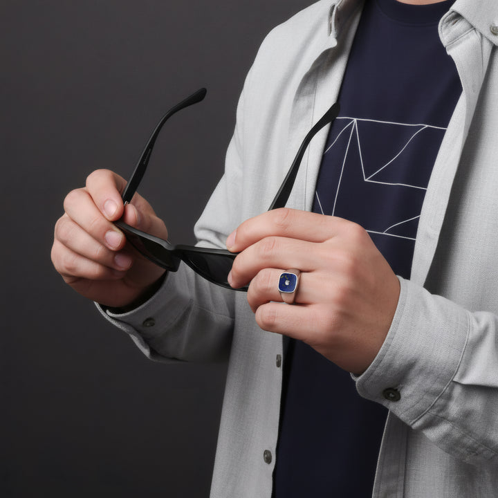 Person holding a pair of sunglasses against a dark background