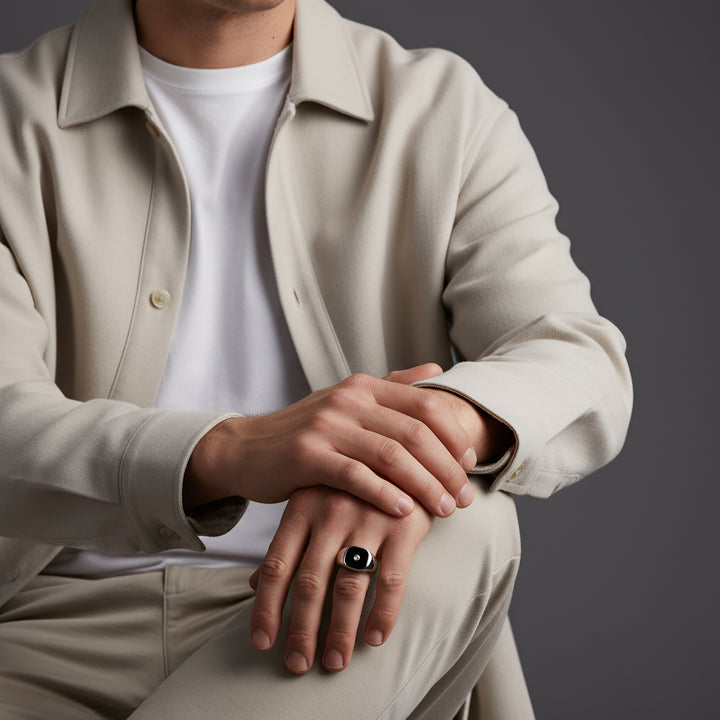 Person wearing a beige jacket and pants with a plain background