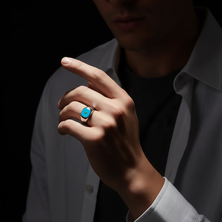 Hand wearing a blue ring with a dark background