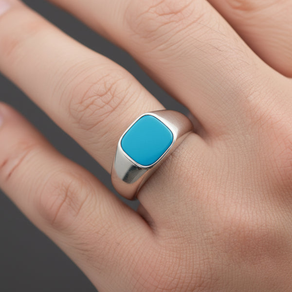 Turquoise stone ring on a person's finger with a neutral background